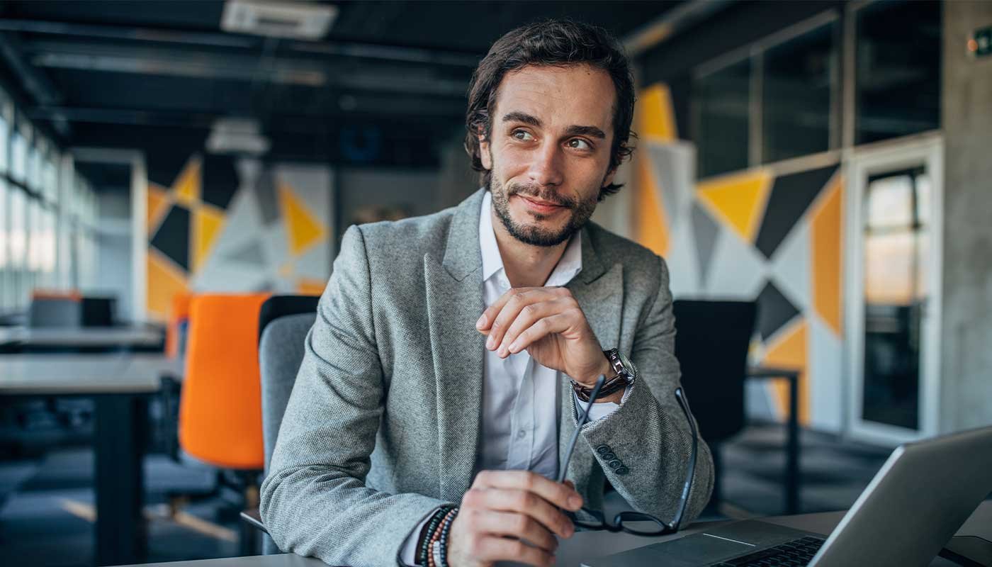 man smiling by laptop