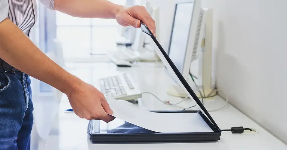 an image of someone manually scanning documents on older equipment