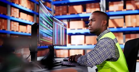 image of a manufacturing professional on his desktop in a warehouse