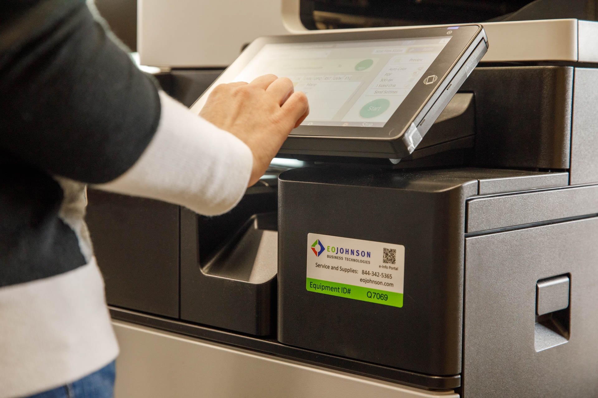 an image of an employee using a multifunction device with an eo johnson sticker on it