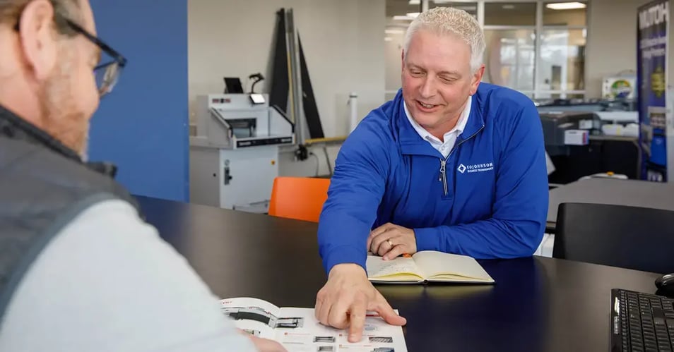 an image of a production print partner reviewing equipment solutions with his client