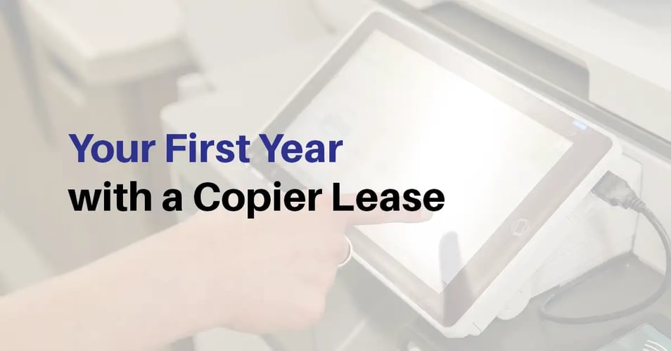 Business professional using a copier touchscreen while reviewing a first-year copier lease