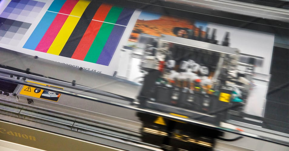 A continuous feed printer testing color in an in-plant print shop before a production print job.