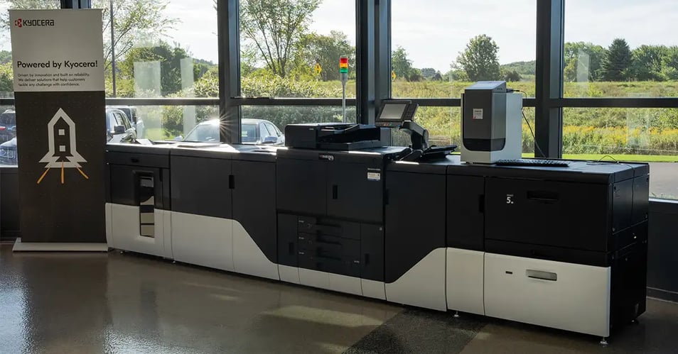 Kyocera TASKalfa Pro 15000c color inkjet production press with inline finishing modules in a bright, window-lit showroom