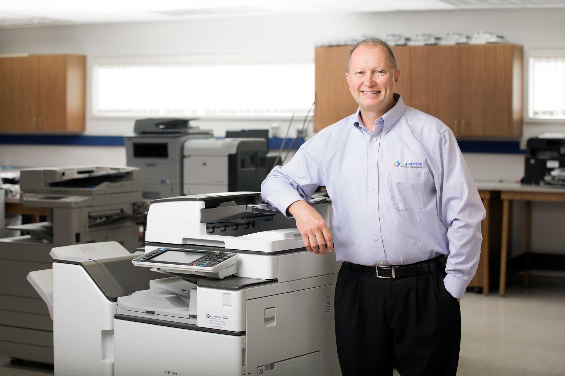 eo_johnson_employee_smiling_next_to_copier