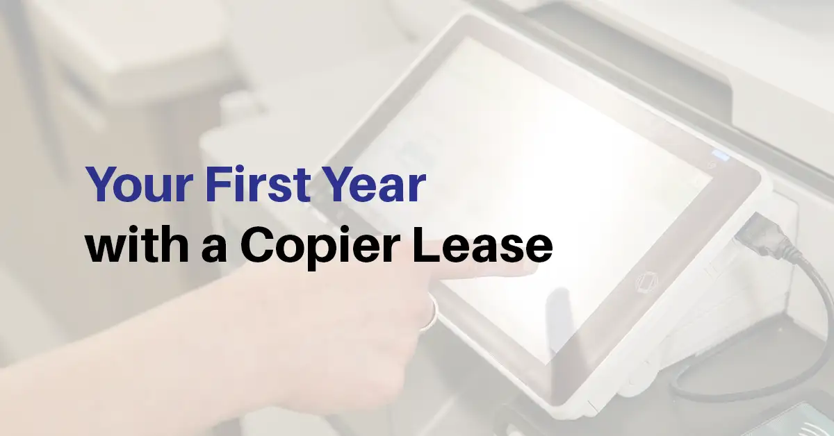 Business professional using a copier touchscreen while reviewing a first-year copier lease